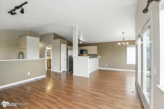 10300 Ridge Park Dr, Anchorage, AK 99507 - unfurnished living room with lofted ceiling, a chandelier, dark wood-style floors, and track lighting