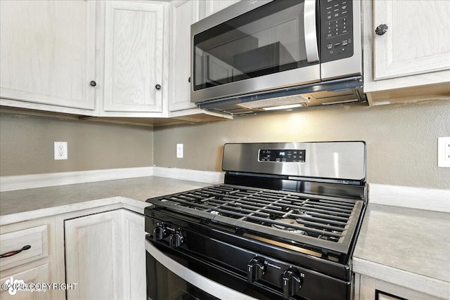 10300 Ridge Park Dr, Anchorage, AK 99507 - kitchen with appliances with stainless steel finishes, light countertops, and white cabinetry