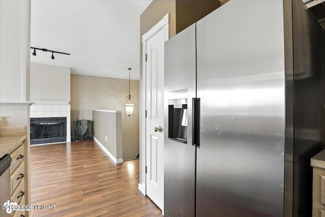 10300 Ridge Park Dr, Anchorage, AK 99507 - kitchen with stainless steel appliances, wood finished floors, rail lighting, a fireplace, and light countertops