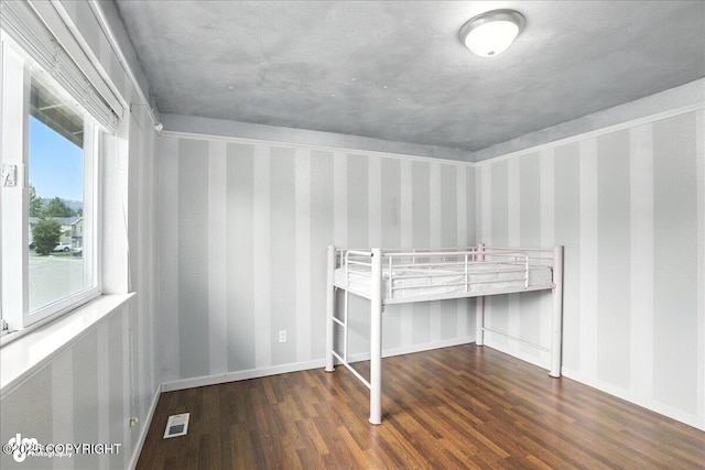 10300 Ridge Park Dr, Anchorage, AK 99507 - unfurnished bedroom with wood finished floors and wallpapered walls