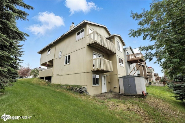 10300 Ridge Park Dr, Anchorage, AK 99507 - rear view of house with a balcony, a shed, a chimney, and a yard