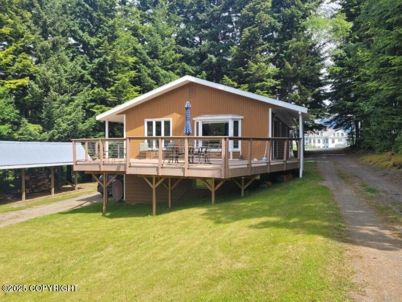 385 S 3rd Ave, Haines, AK 99827 - view of front of house featuring a deck, a front yard, and dirt driveway
