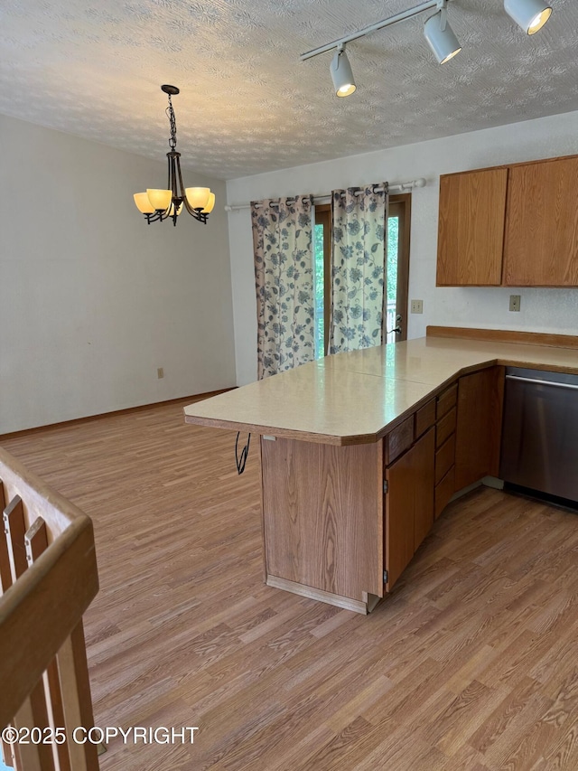 4261 E Foxtrot Ave, Wasilla, AK 99654 - kitchen with dishwasher, a chandelier, light wood-style flooring, a peninsula, and a textured ceiling