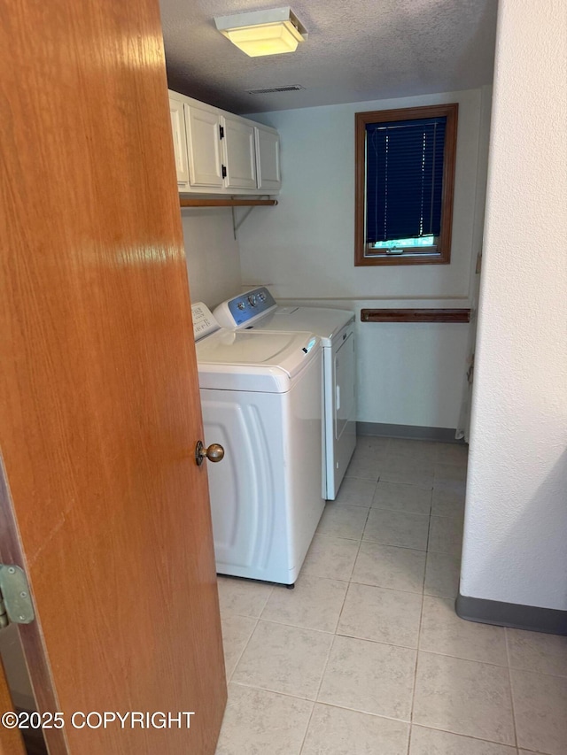 4261 E Foxtrot Ave, Wasilla, AK 99654 - laundry area featuring cabinet space, washer and dryer, light tile patterned floors, and a textured ceiling