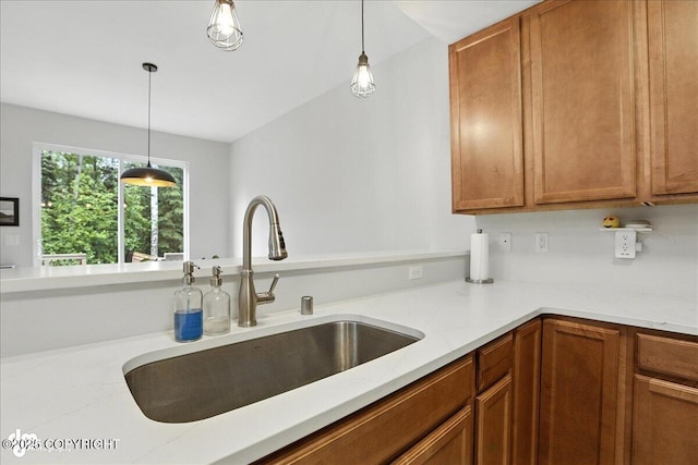 20454 Icefall Dr, Eagle River, AK 99577 - kitchen with hanging light fixtures, brown cabinets, and light stone counters