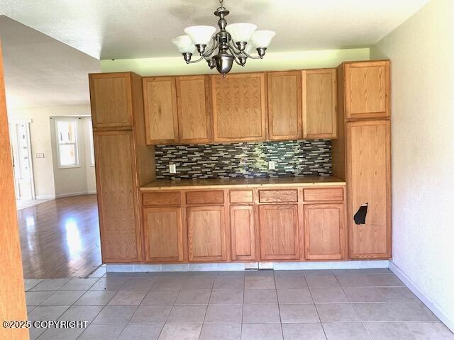 7367 S Rubacaba St, Wasilla, AK 99623 - kitchen featuring a chandelier, tasteful backsplash, decorative light fixtures, and light tile patterned floors