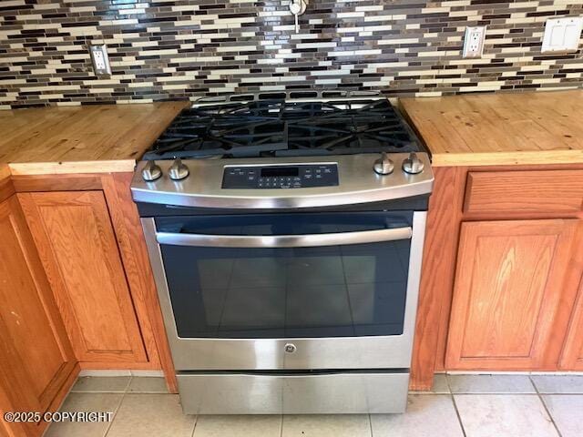 7367 S Rubacaba St, Wasilla, AK 99623 - kitchen view of stainless steel gas range, wood counters, and decorative backsplash