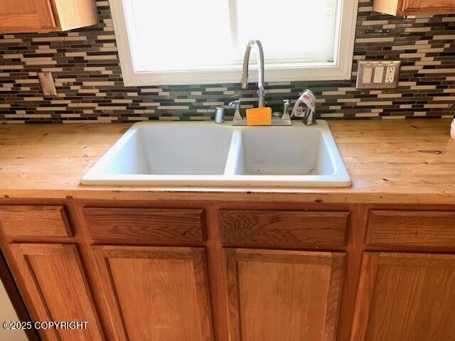 7367 S Rubacaba St, Wasilla, AK 99623 - kitchen featuring backsplash and brown cabinetry