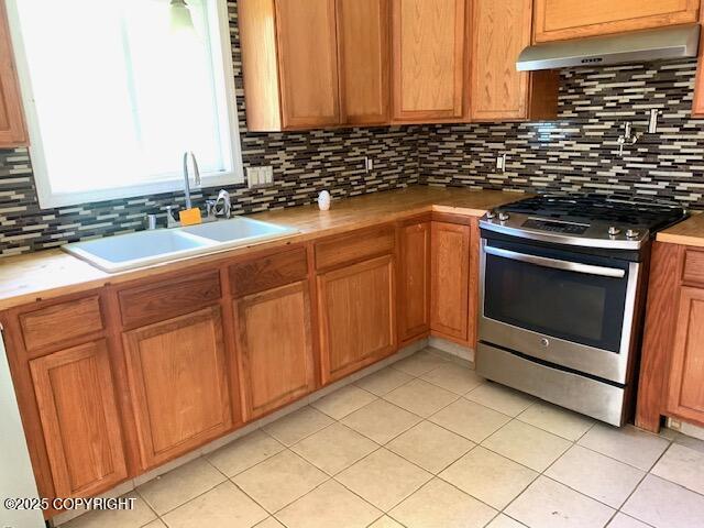 7367 S Rubacaba St, Wasilla, AK 99623 - kitchen featuring gas stove, under cabinet range hood, tasteful backsplash, and light tile patterned floors