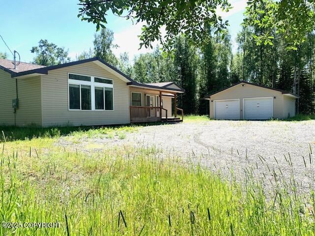 7367 S Rubacaba St, Wasilla, AK 99623 - view of yard featuring a detached garage, an outbuilding, and a porch