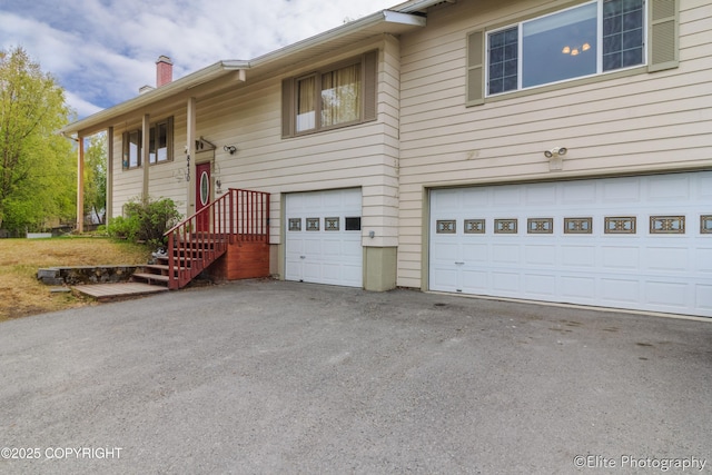 8430 Greenhill Way, Anchorage, AK 99502 - split foyer home with a garage, a chimney, and driveway