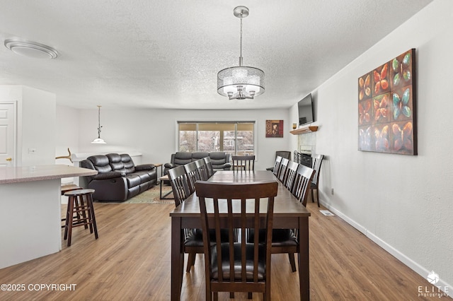 8430 Greenhill Way, Anchorage, AK 99502 - dining area featuring a textured ceiling, a chandelier, and light wood-style floors