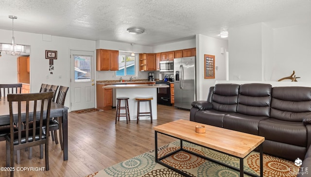 8430 Greenhill Way, Anchorage, AK 99502 - living room with light wood-style flooring, a textured ceiling, and a chandelier