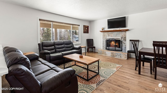 8430 Greenhill Way, Anchorage, AK 99502 - living area with light wood-type flooring, a tiled fireplace, and a textured ceiling