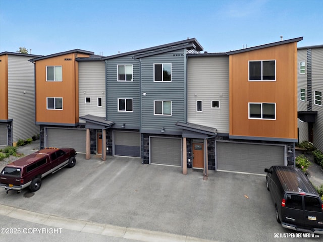 11459 Moonrise Ridge Pl # 7, Anchorage, AK 99516 - view of front of home featuring a garage, stone siding, and driveway