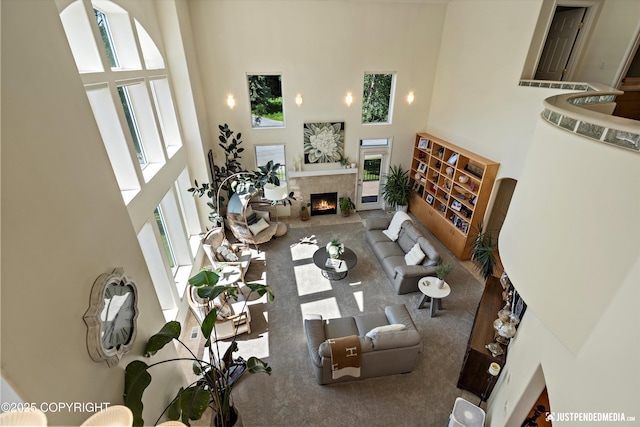 2231 Shore Dr, Anchorage, AK 99515 - carpeted living area featuring a towering ceiling and a lit fireplace
