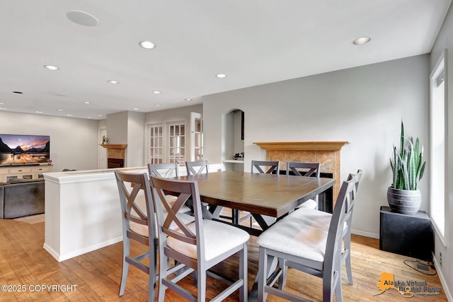 7521 Labrador Cir, Anchorage, AK 99502 - dining area featuring a tile fireplace, recessed lighting, and light wood-type flooring