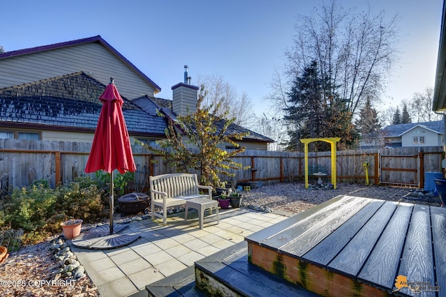 7521 Labrador Cir, Anchorage, AK 99502 - fenced backyard featuring a patio and an outdoor fire pit