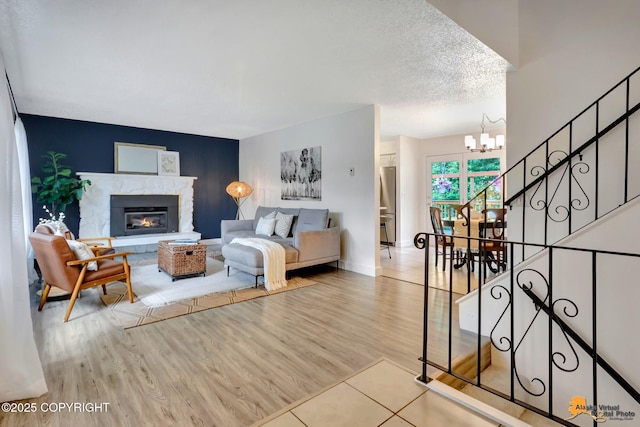 3116 Briarcliff Dr, Anchorage, AK 99508 - living room featuring a chandelier, a glass covered fireplace, stairs, wood finished floors, and an accent wall