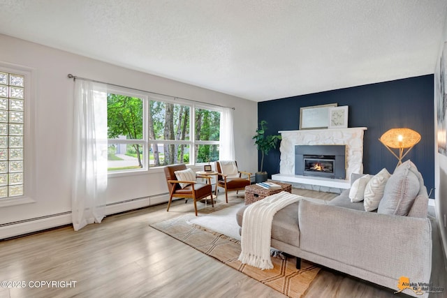 3116 Briarcliff Dr, Anchorage, AK 99508 - living room featuring healthy amount of natural light, wood finished floors, a stone fireplace, a textured ceiling, and an accent wall