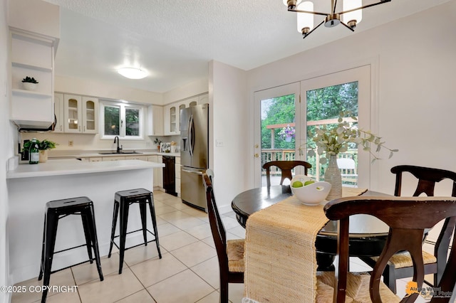 3116 Briarcliff Dr, Anchorage, AK 99508 - dining space with light tile patterned flooring, a chandelier, and a textured ceiling