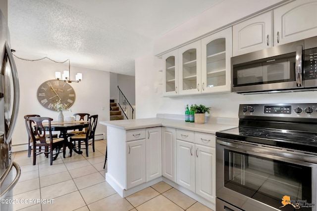 3116 Briarcliff Dr, Anchorage, AK 99508 - kitchen with stainless steel appliances, white cabinets, light tile patterned floors, a peninsula, and a textured ceiling