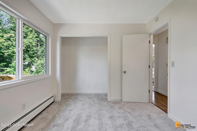 3116 Briarcliff Dr, Anchorage, AK 99508 - unfurnished bedroom with a baseboard radiator, multiple windows, carpet, and a textured ceiling