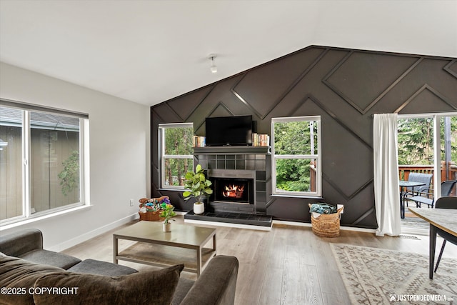 9755 Newhaven Loop, Anchorage, AK 99507 - living area with healthy amount of natural light, wood finished floors, a fireplace, and vaulted ceiling