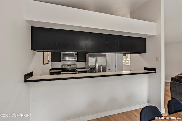 9755 Newhaven Loop, Anchorage, AK 99507 - kitchen with appliances with stainless steel finishes, wood finished floors, and a peninsula
