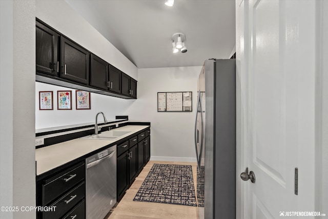 9755 Newhaven Loop, Anchorage, AK 99507 - kitchen featuring appliances with stainless steel finishes, dark cabinets, light wood-style flooring, and light countertops