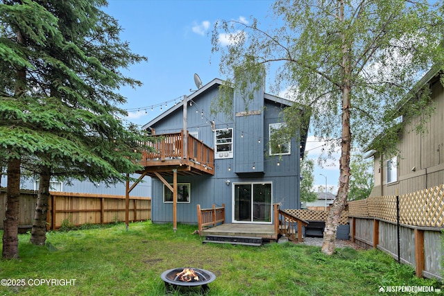 9755 Newhaven Loop, Anchorage, AK 99507 - rear view of house with an outdoor fire pit, a fenced backyard, and a wooden deck