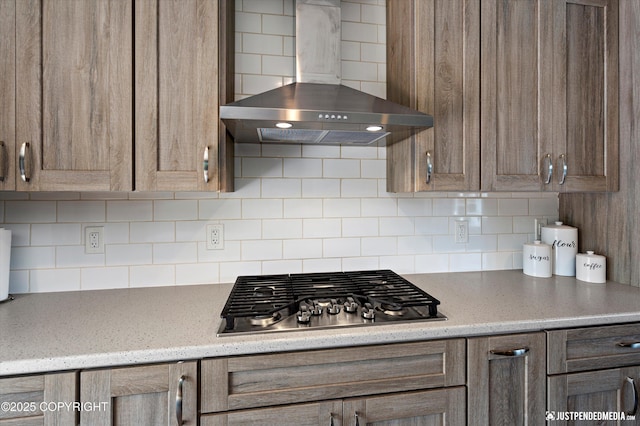 8410 E 20th Ave, Anchorage, AK 99504 - kitchen with wall chimney range hood, stainless steel gas stovetop, backsplash, and light stone countertops