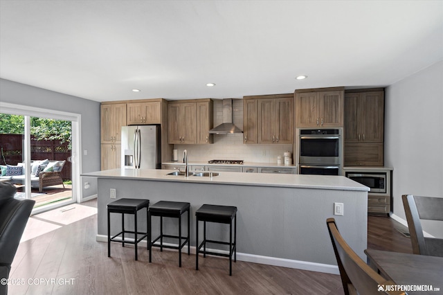 8410 E 20th Ave, Anchorage, AK 99504 - kitchen with stainless steel appliances, wall chimney range hood, light countertops, a large island, and wood finished floors