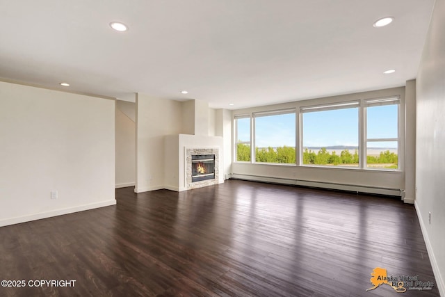 1414 W 7th Ave # 3, Anchorage, AK 99501 - unfurnished living room with a baseboard radiator, dark wood-type flooring, recessed lighting, and a fireplace