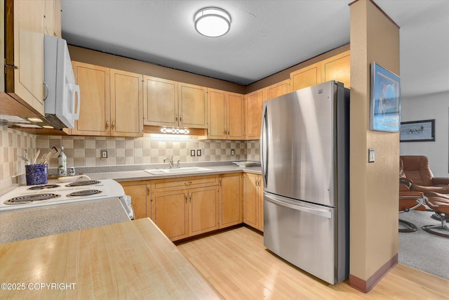 12145 Rainbow Ave, Anchorage, AK 99516 - kitchen with freestanding refrigerator, light countertops, light wood-style flooring, white microwave, and light brown cabinetry