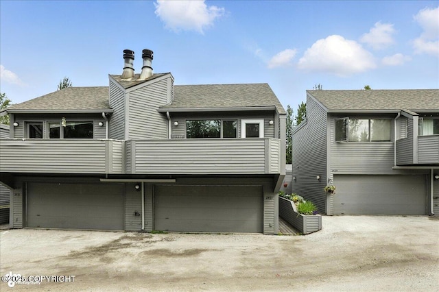 2433 La Honda Dr, Anchorage, AK 99517 - rear view of property featuring a garage, a balcony, driveway, and a shingled roof