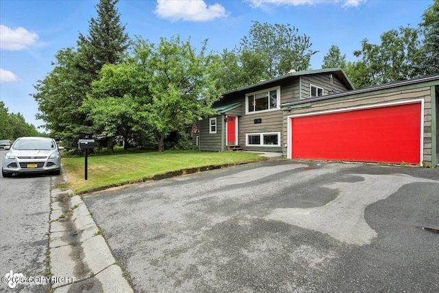 4733 Becharof St, Anchorage, AK 99507 - view of front of house featuring a front lawn, asphalt driveway, and an attached garage
