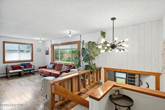 4733 Becharof St, Anchorage, AK 99507 - living area with a textured ceiling, hardwood / wood-style flooring, plenty of natural light, a chandelier, and wooden walls