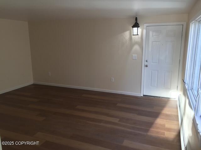 420 E 14th Ave, Anchorage, AK 99501 - unfurnished room featuring dark wood finished floors and a baseboard heating unit