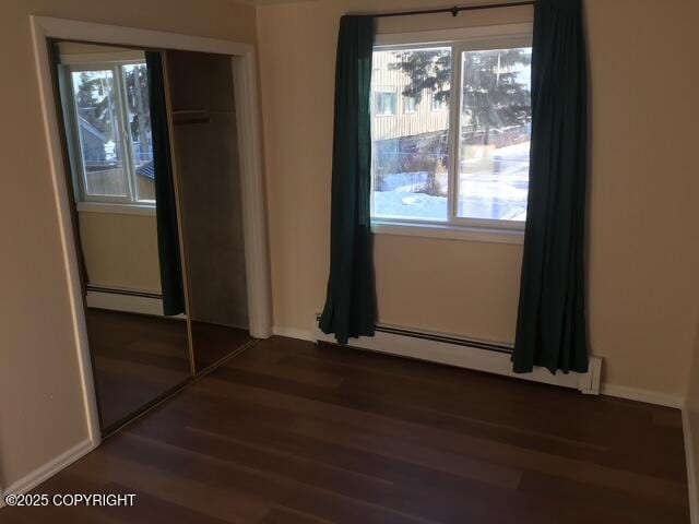 420 E 14th Ave, Anchorage, AK 99501 - unfurnished bedroom with a baseboard heating unit and wood finished floors
