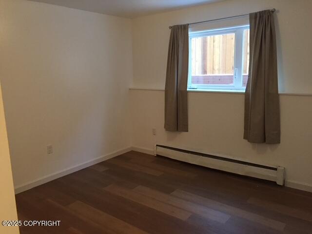 420 E 14th Ave, Anchorage, AK 99501 - spare room with a baseboard radiator and dark wood finished floors