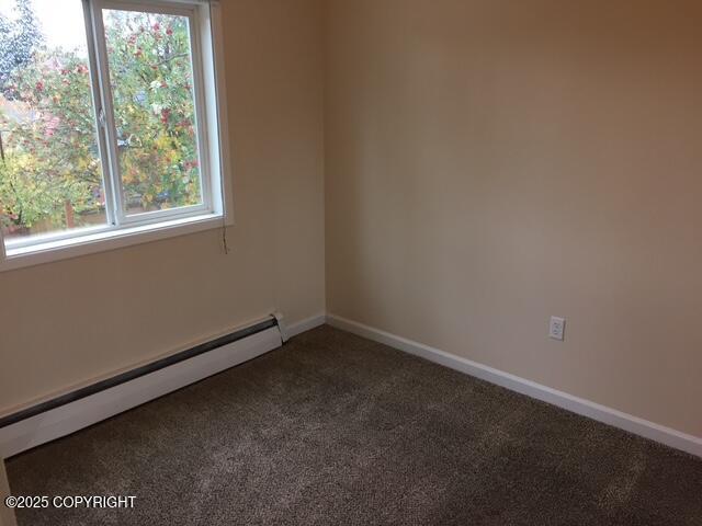 420 E 14th Ave, Anchorage, AK 99501 - carpeted spare room featuring a baseboard heating unit and healthy amount of natural light