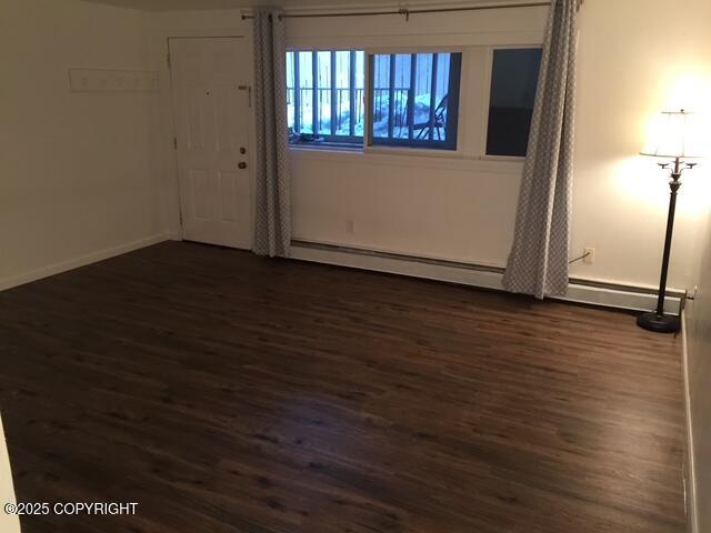 420 E 14th Ave, Anchorage, AK 99501 - empty room featuring dark wood-type flooring and a baseboard radiator