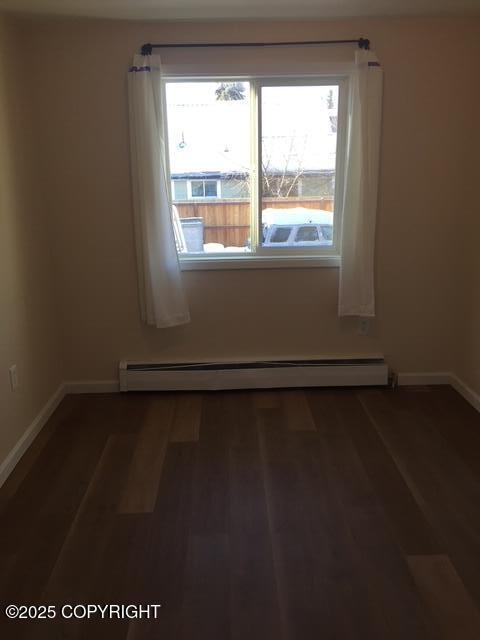 420 E 14th Ave, Anchorage, AK 99501 - empty room with baseboard heating and wood finished floors