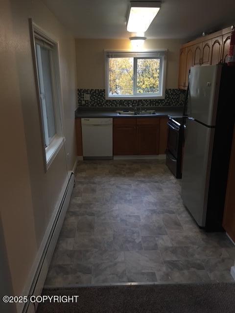 420 E 14th Ave, Anchorage, AK 99501 - kitchen featuring dishwasher, freestanding refrigerator, a baseboard radiator, electric range, and dark countertops