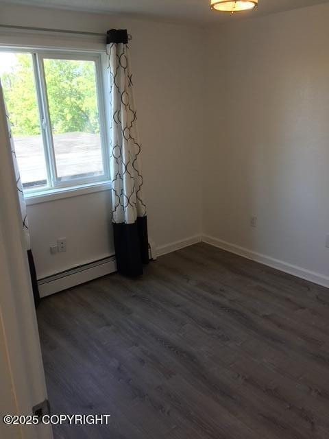 420 E 14th Ave, Anchorage, AK 99501 - unfurnished room featuring a baseboard radiator and dark wood finished floors