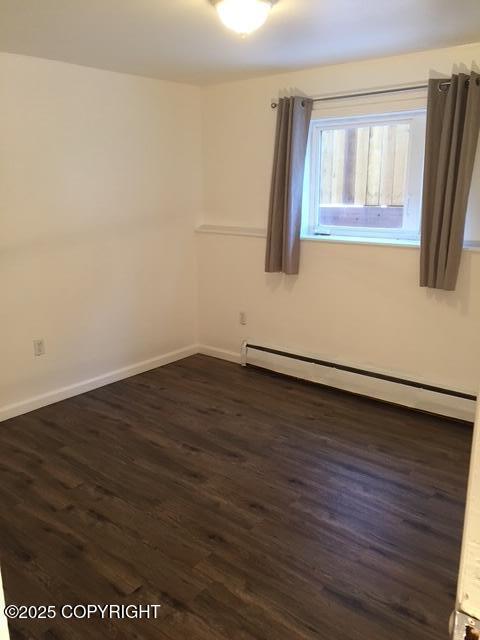420 E 14th Ave, Anchorage, AK 99501 - empty room featuring a baseboard radiator and dark wood-type flooring