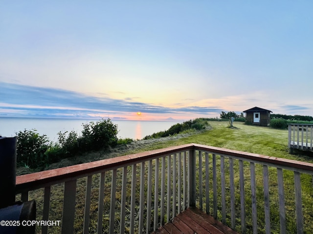 32425 Sterling Hwy, Anchor Point, AK 99556 - deck at dusk with an outbuilding, a water view, and a lawn