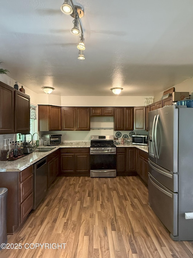 54110 Field Dr, Nikiski/North Kenai, AK 99611 - kitchen with appliances with stainless steel finishes, wood finished floors, and dark brown cabinets