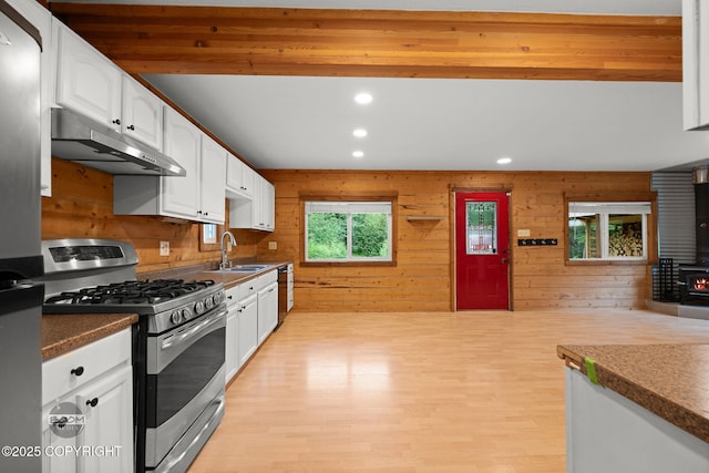 1291 N Rainbow Park Dr, Wasilla, AK 99623 - kitchen featuring stainless steel appliances, under cabinet range hood, a wood stove, white cabinets, and recessed lighting